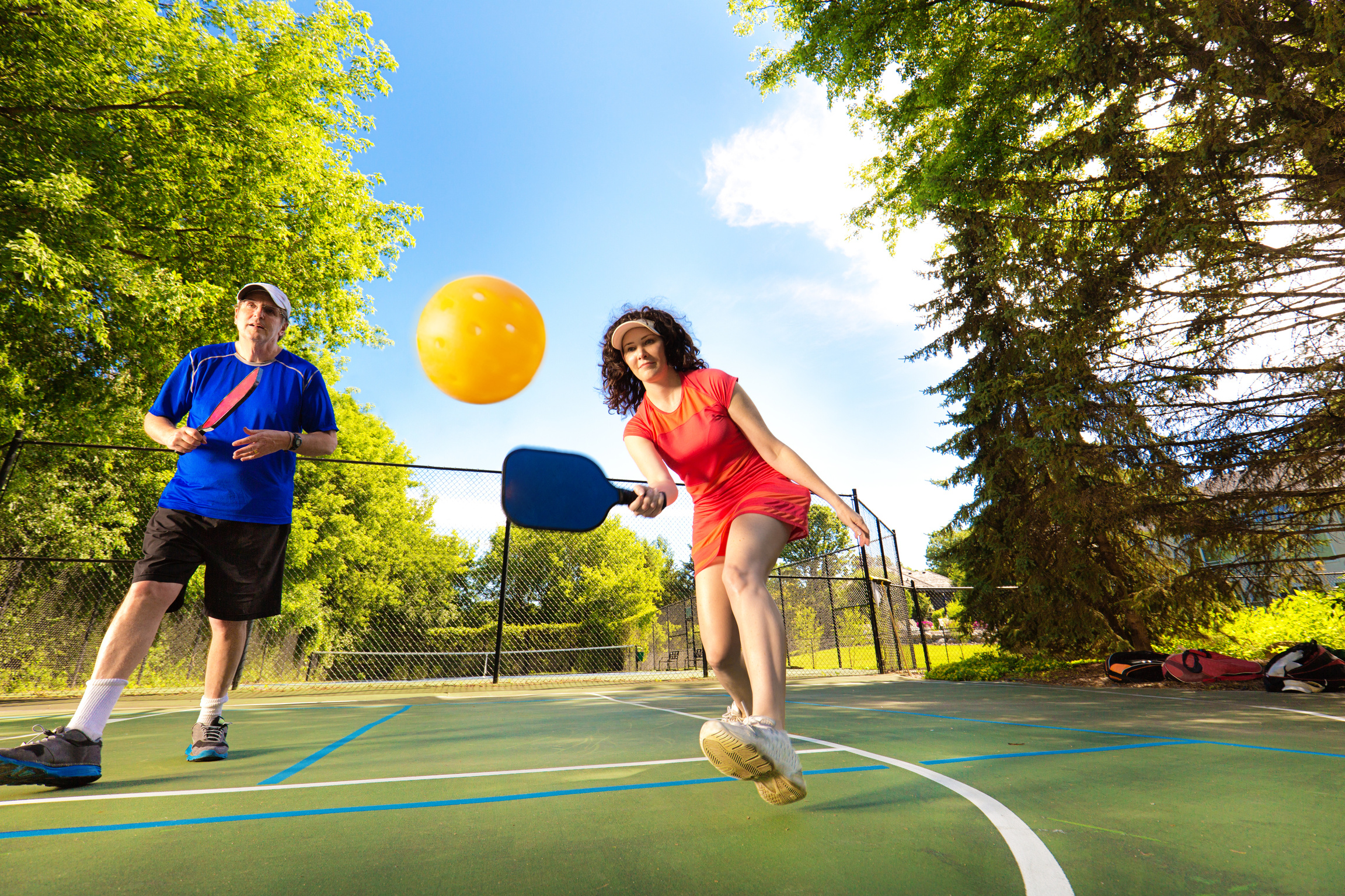 Adult Man and Woman Pickleball Player Playing Pickleball in Court